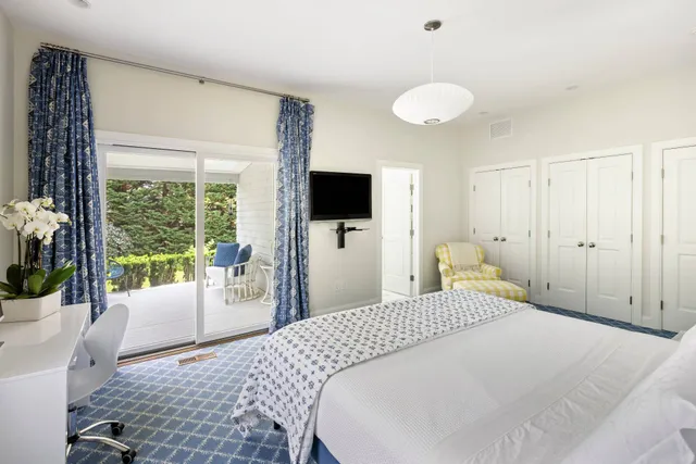 a bedroom with a large bed and a flat tv screen