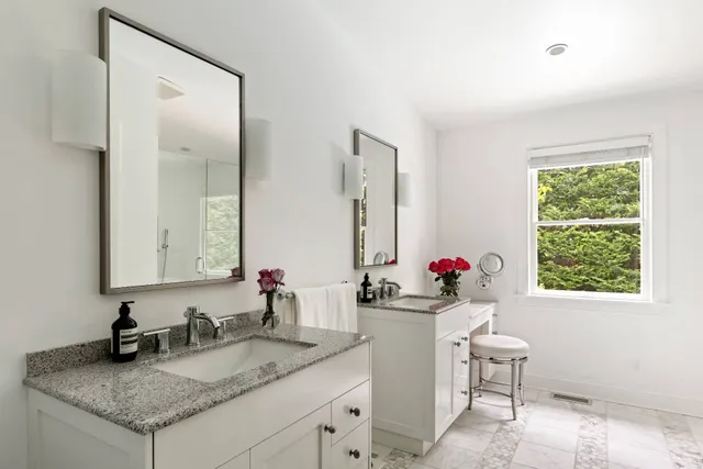 a bathroom with a granite countertop sink a mirror and a window