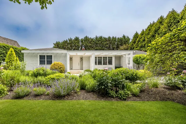 a front view of house with a garden