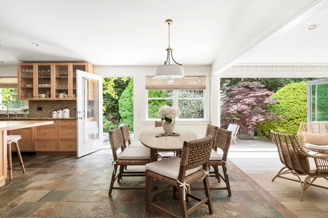 a dining room with furniture a chandelier and large windows
