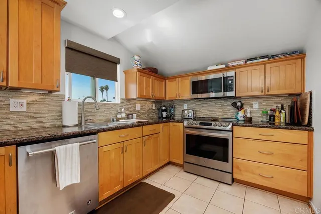 a kitchen with stainless steel appliances granite countertop a stove sink and cabinets