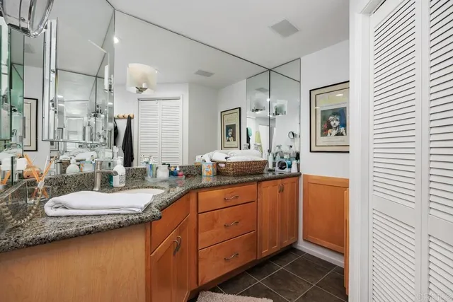 a spacious bathroom with a granite countertop sink and a mirror