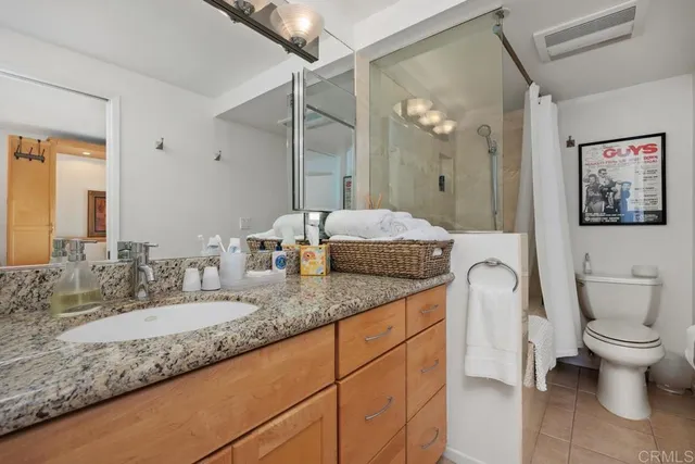 a bathroom with a granite countertop sink mirror and toilet