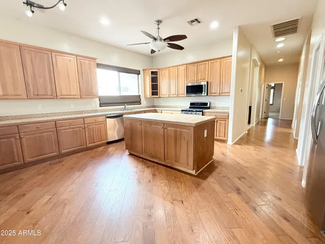 a large kitchen with stainless steel appliances granite countertop a stove and cabinets
