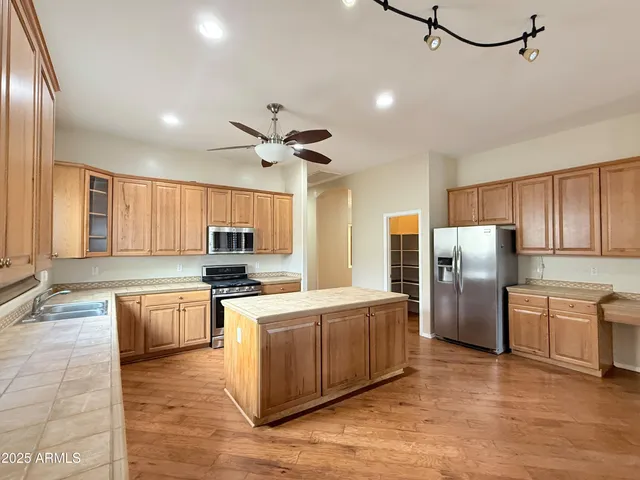 a kitchen with stainless steel appliances a refrigerator and a stove top oven
