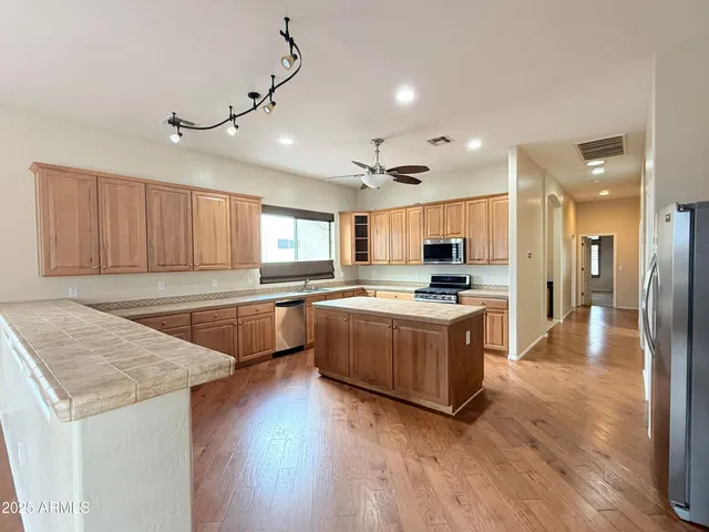 a large kitchen with a center island and stainless steel appliances