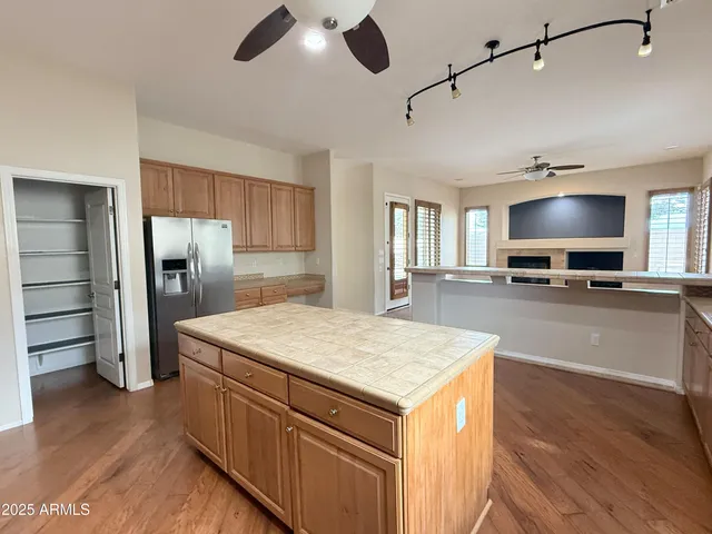 a kitchen with stainless steel appliances kitchen island a refrigerator sink and cabinets