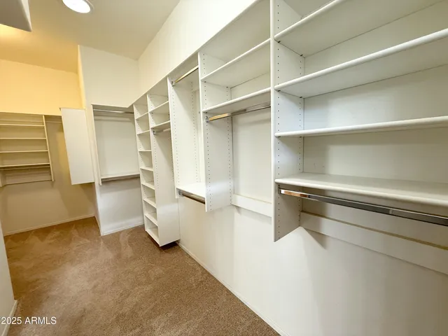 a view of walk in closet with empty racks