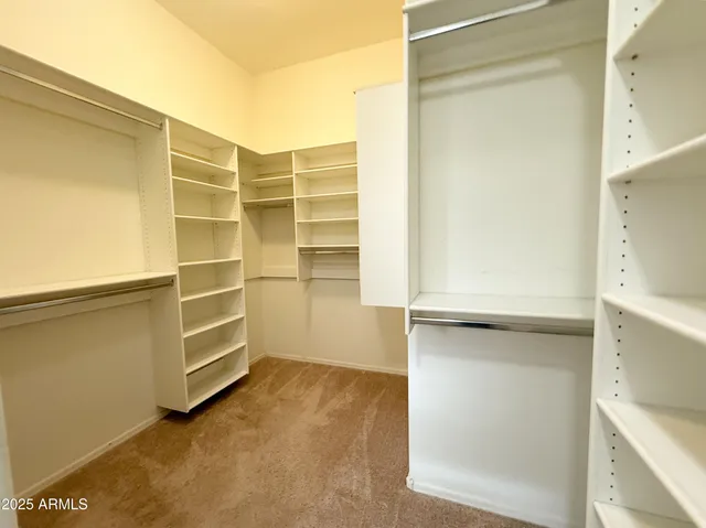 a view of walk in closet with empty racks