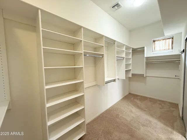 a view of an empty walk in closet and a window