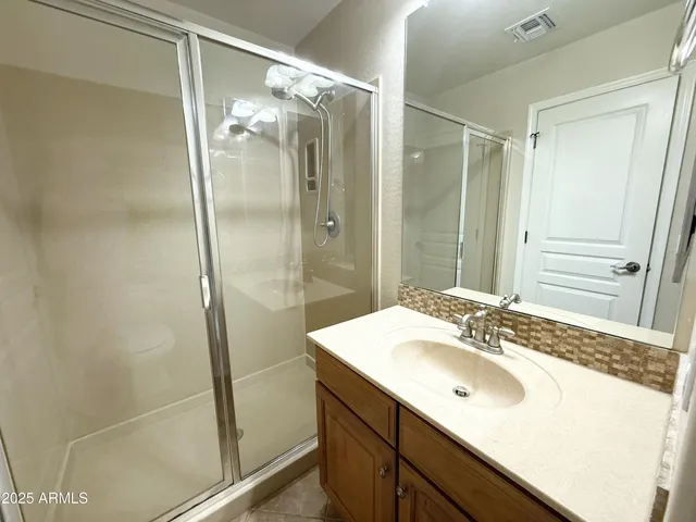 a bathroom with a shower sink vanity and a mirror