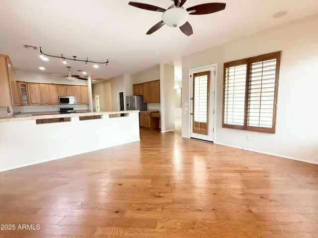 a view of a kitchen with cabinets stainless steel appliances a window and a counter top space