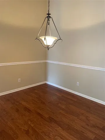 a view of a room with wooden floor and white walls
