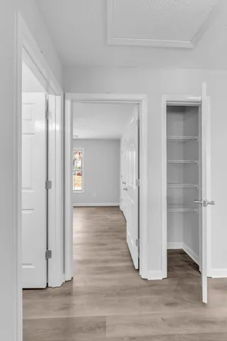 a view of a room with wooden floor & entryway