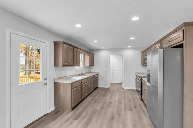 a view of a kitchen with a sink and a refrigerator