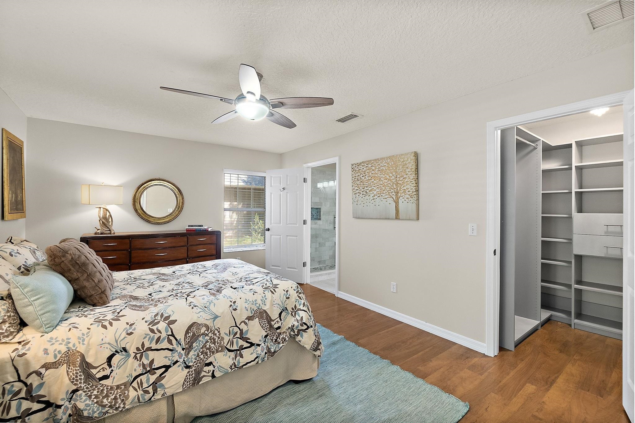 3253 Turtle Creek Road St. Augustine, FL 32086 - Photo 16 of 40 Bedroom with a spacious closet, dark wood-type flooring, ceiling fan, a textured ceiling, and ensuite bathroom