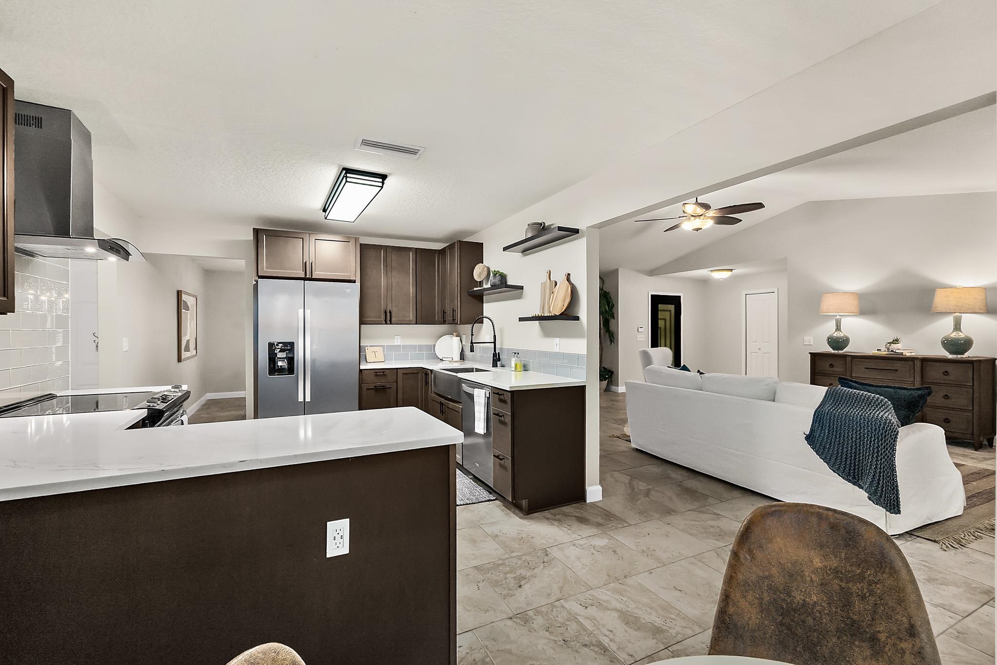 3253 Turtle Creek Road St. Augustine, FL 32086 - Photo 40 of 40 Kitchen featuring dark wood finish cabinets, stainless steel appliances, a peninsula, open shelves, and open floor plan
