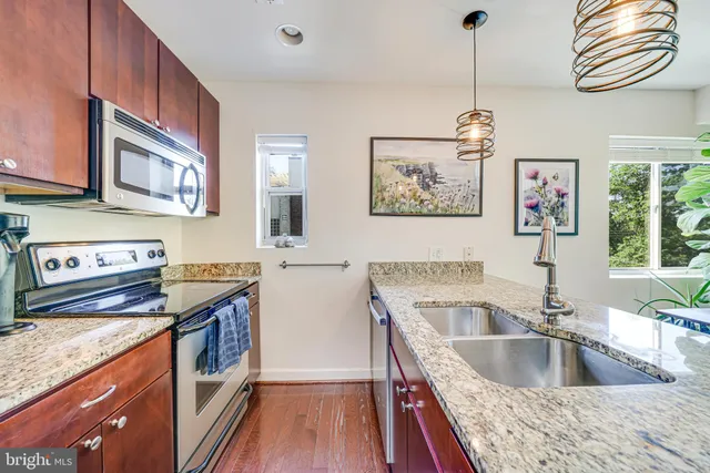a kitchen with stainless steel appliances granite countertop a refrigerator stove and sink