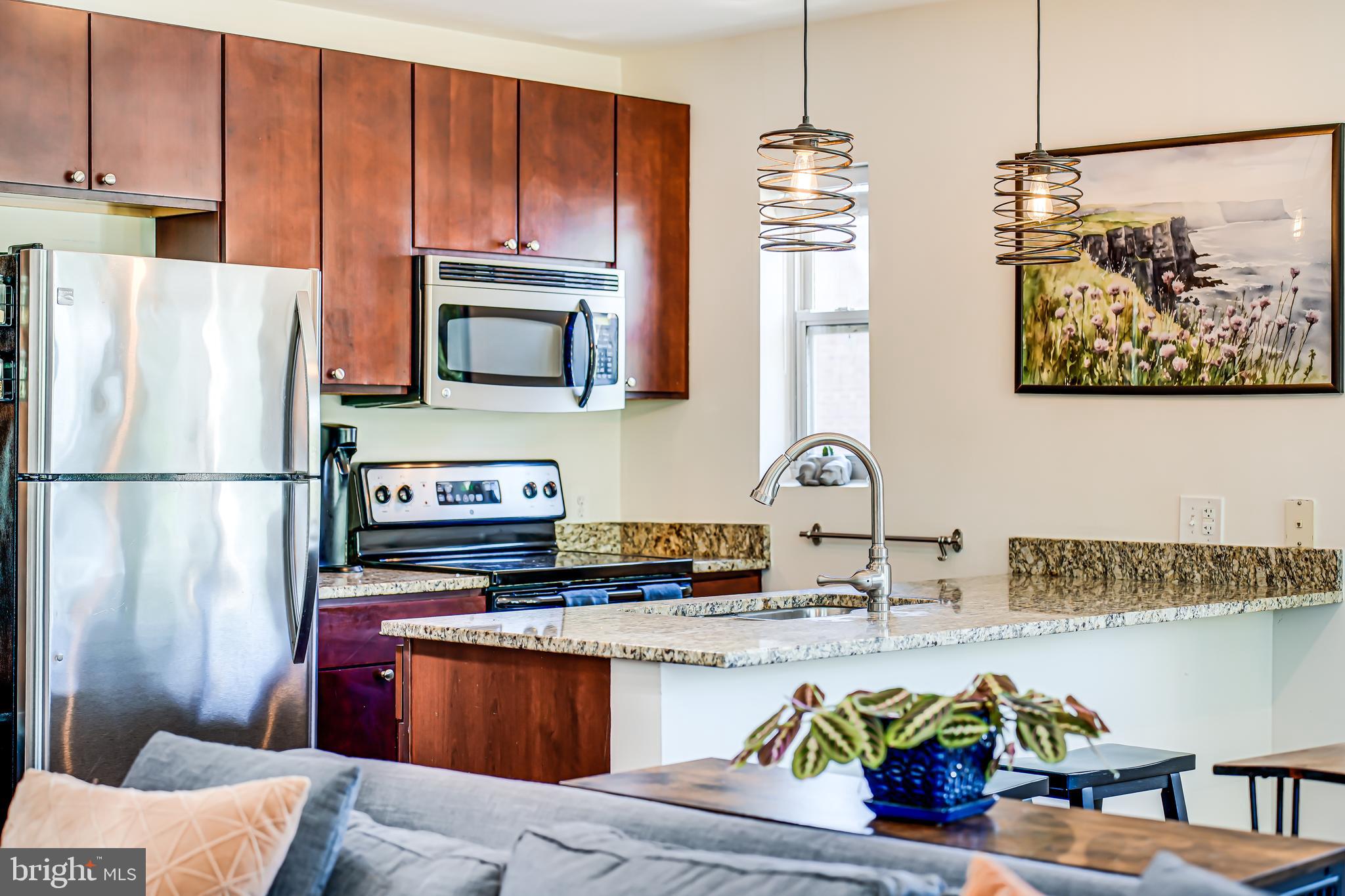 5407 9th Street Northwest, Unit 310 Washington, DC 20011 - Photo 22 of 53 a kitchen with stainless steel appliances granite countertop a refrigerator stove and sink