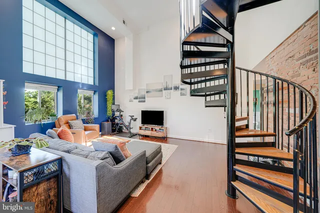a living room with furniture a flat screen tv and a window