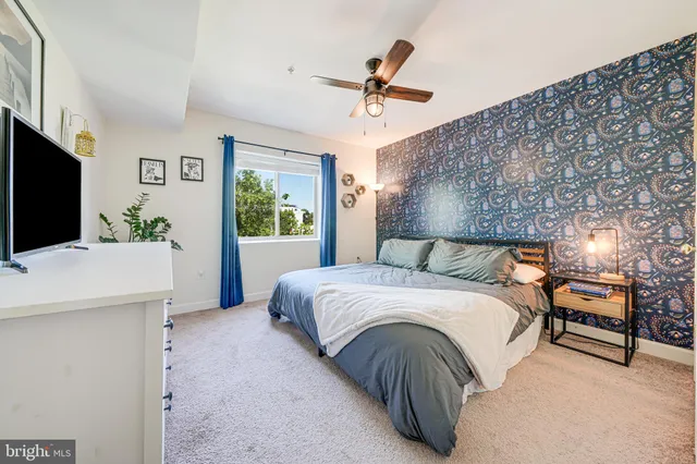 a bedroom with a large bed and a flat tv screen on dresser