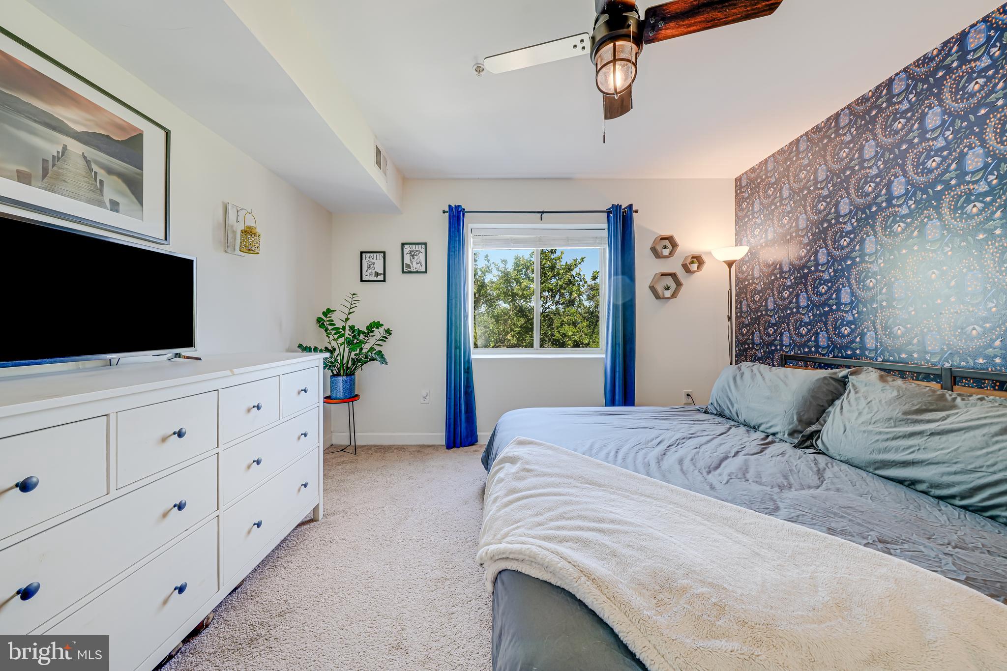 5407 9th Street Northwest, Unit 310 Washington, DC 20011 - Photo 33 of 53 a bedroom with a large bed and a flat tv screen on dresser