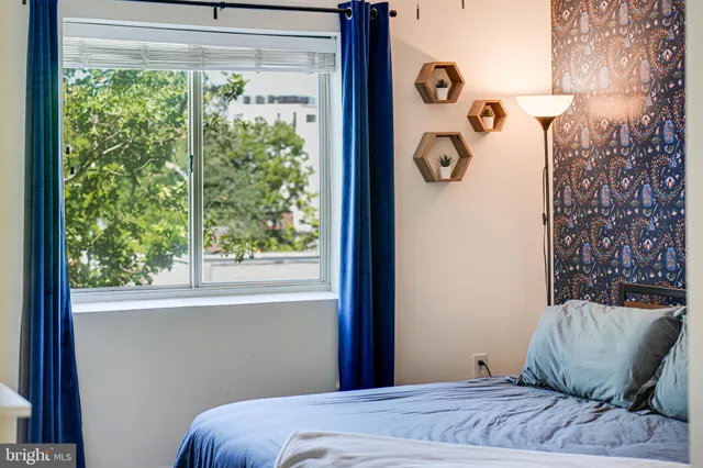 a bedroom with a large bed and a flat tv screen on dresser