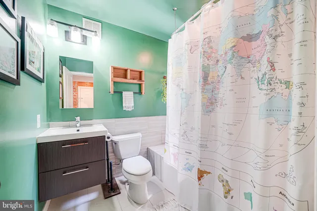 a bathroom with a toilet sink vanity and mirror