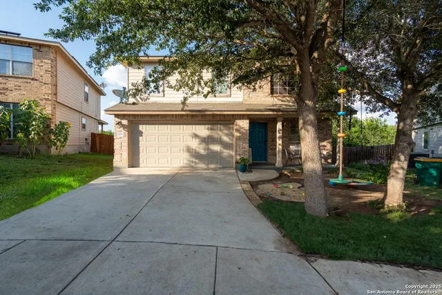 a front view of a house with a yard and fountain