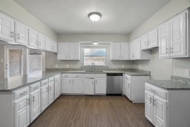 a kitchen with granite countertop white cabinets and white stainless steel appliances