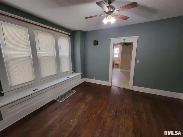a view of an empty room and window with wooden floor