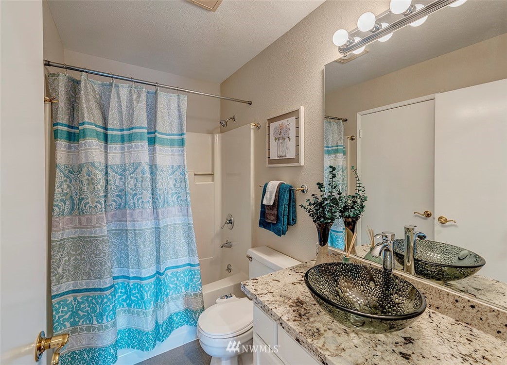 7501 Old Redmond Road, Unit 414 Redmond, WA 98052 - Photo 13 of 22 a bathroom with a granite countertop sink a toilet a mirror and shower