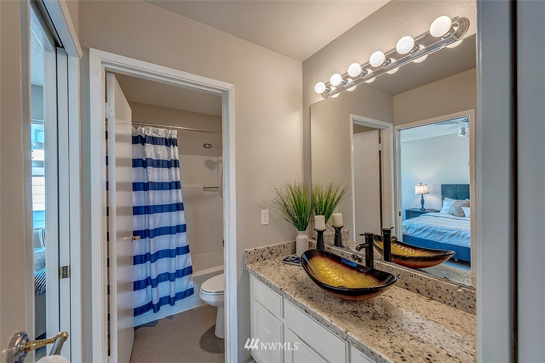 7501 Old Redmond Road, Unit 414 Redmond, WA 98052 - Photo 16 of 22 a bathroom with a granite countertop sink a mirror and a shower