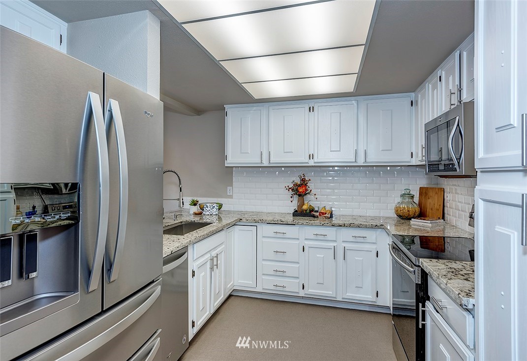 7501 Old Redmond Road, Unit 414 Redmond, WA 98052 - Photo 3 of 22 a kitchen with stainless steel appliances granite countertop a refrigerator sink and cabinets
