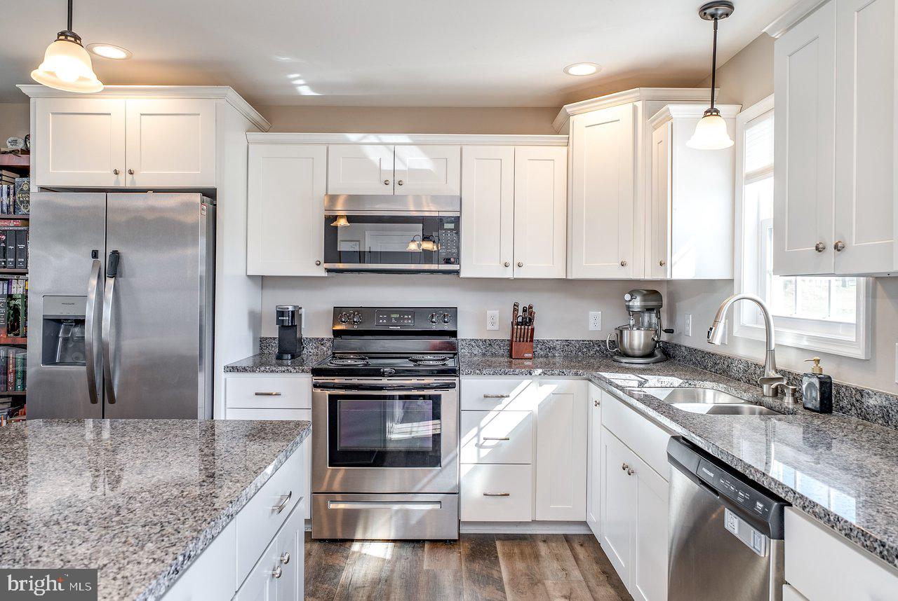107 8th Street Grottoes, VA 24441 - Photo 13 of 45 a kitchen with kitchen island granite countertop a sink appliances cabinets and counter space