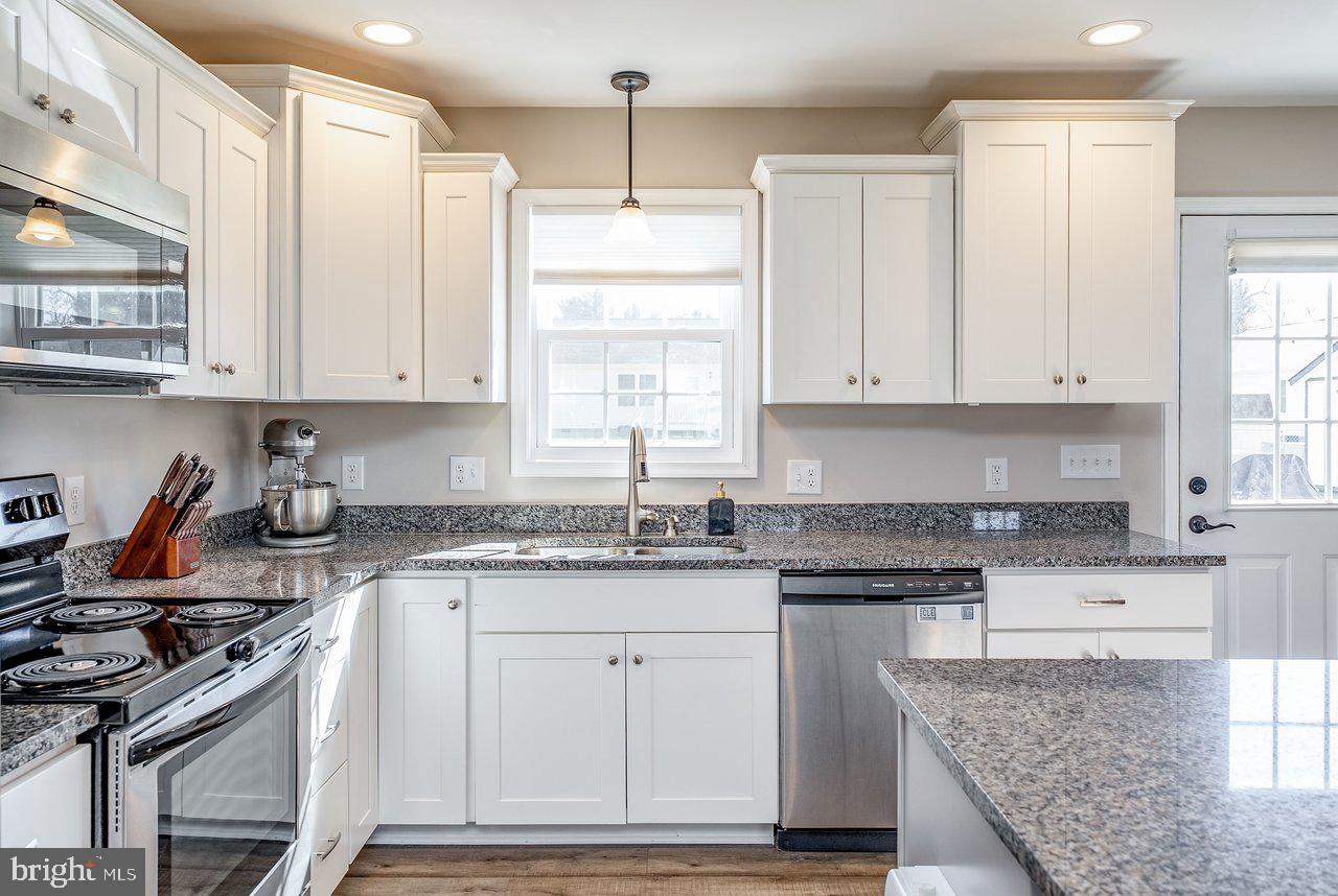 107 8th Street Grottoes, VA 24441 - Photo 14 of 45 a kitchen with granite countertop a stove sink and cabinets