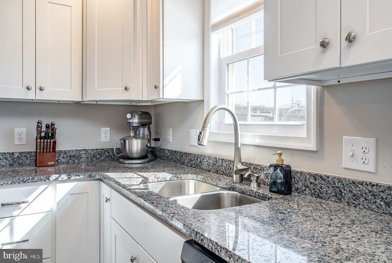 107 8th Street Grottoes, VA 24441 - Photo 15 of 45 a kitchen with granite countertop a sink a stove and cabinets