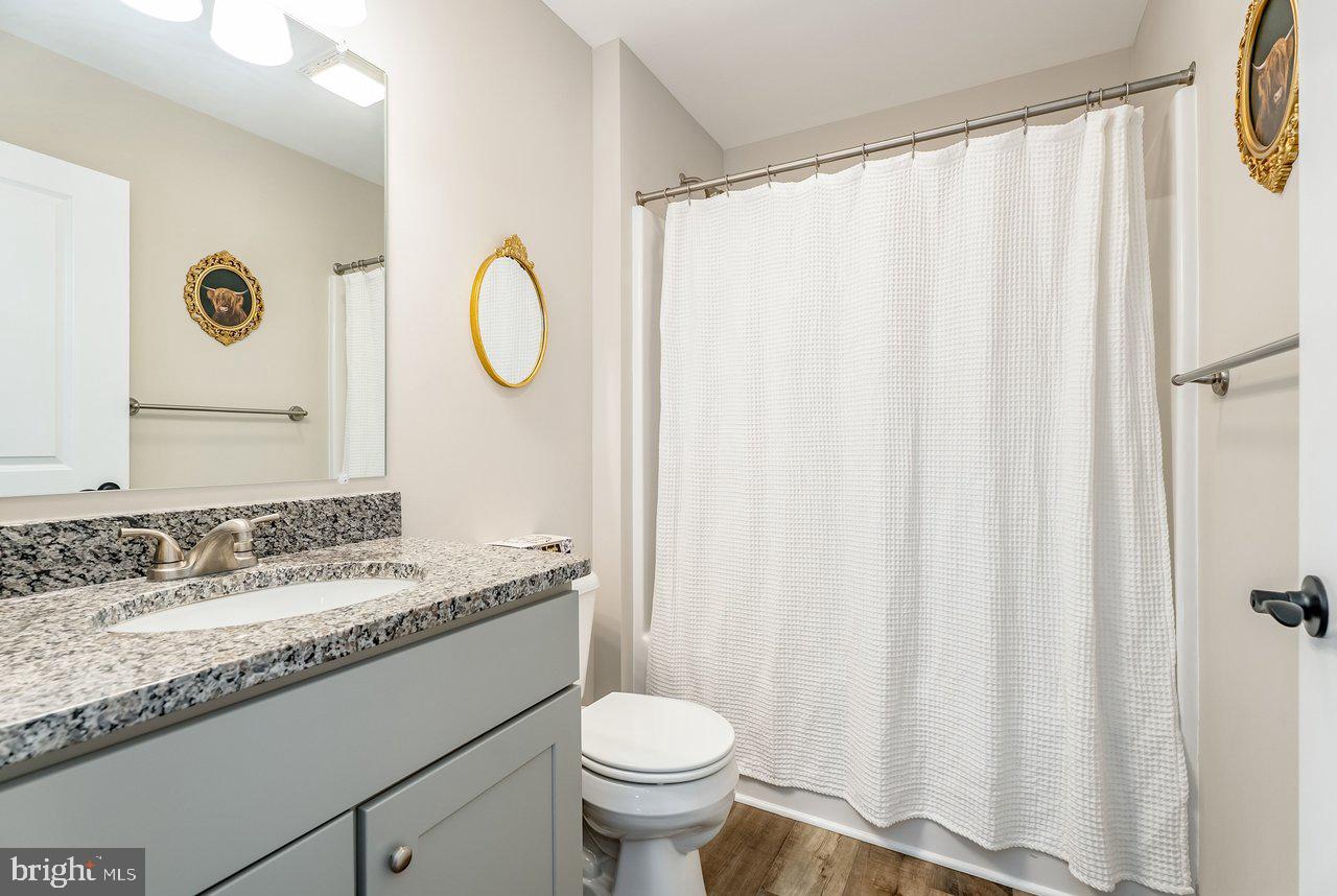 107 8th Street Grottoes, VA 24441 - Photo 26 of 45 a bathroom with a granite countertop sink toilet and a mirror