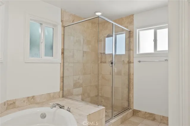 a bedroom with two beds and a large window