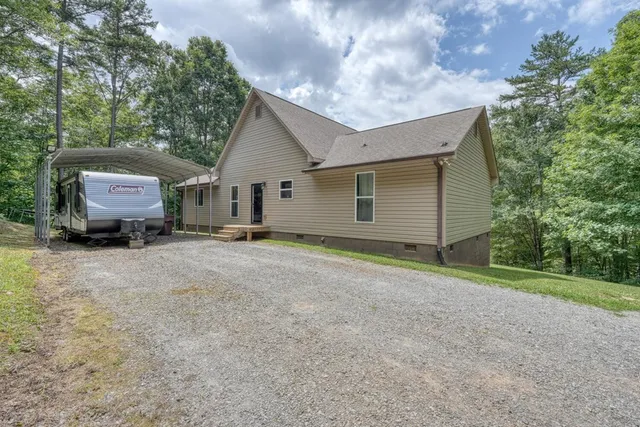 a view of a house with backyard and trees