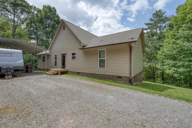 a view of a house with a yard and a large tree