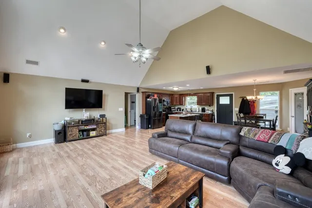 a living room with furniture a flat screen tv and a large window