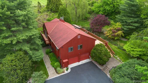 an aerial view of residential houses with outdoor space and trees
