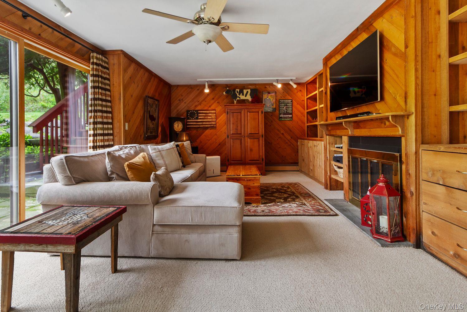 12 Ilana Court Armonk, NY 10504 - Photo 8 of 33 a living room with furniture a flat screen tv and a fireplace