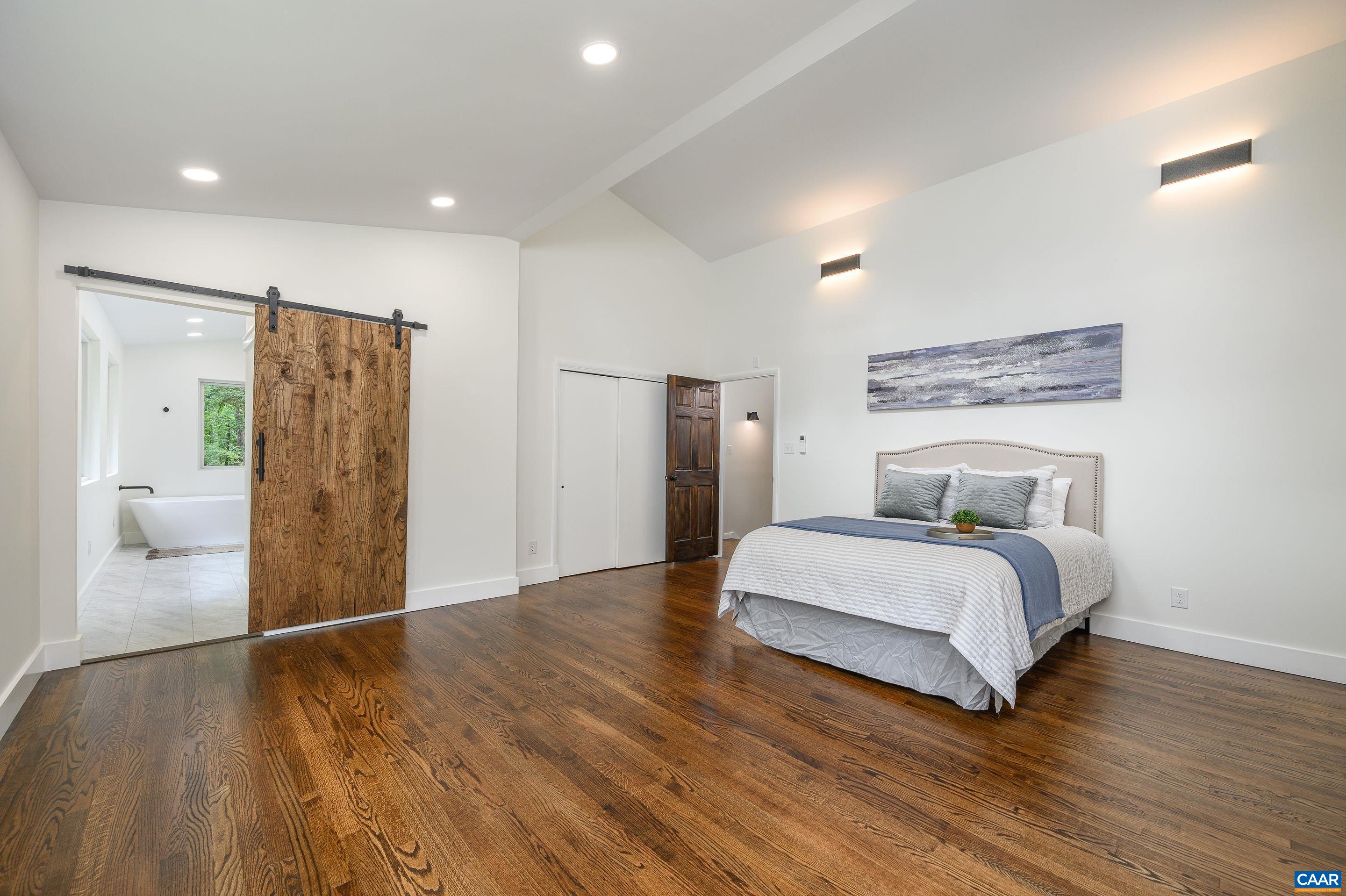 960 Broad Axe Road Charlottesville, VA 22903 - Photo 25 of 39 a spacious bedroom with a bed and a table