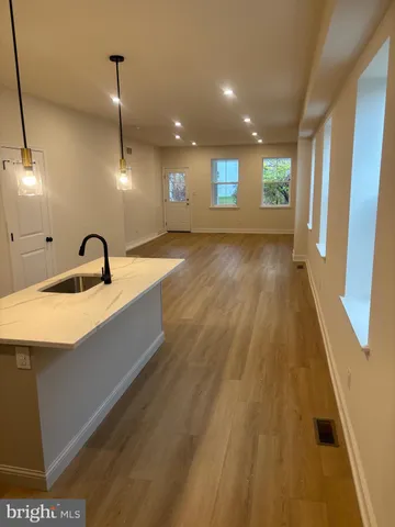 a view of a kitchen with a sink and wooden floor