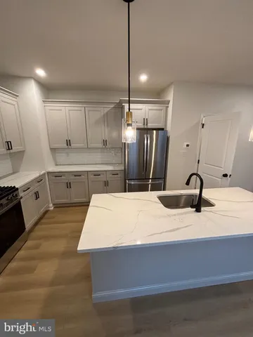 a kitchen with kitchen island white cabinets and stainless steel appliances