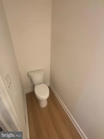 a white toilet sitting next to a white wall