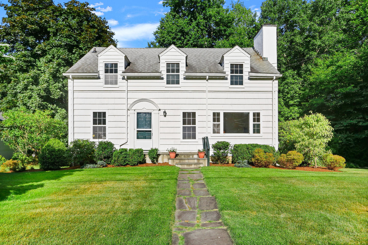 a front view of house with yard and green space