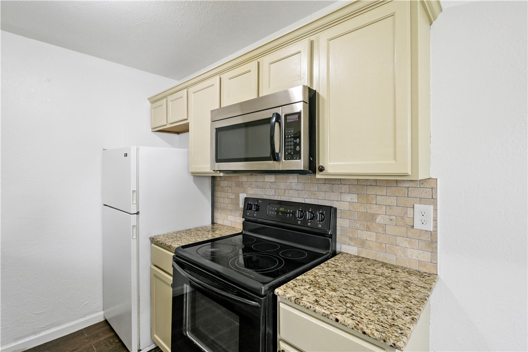 1503 Alpine Circle, Unit A College Station, TX 77840 - Photo 12 of 18 a kitchen with stainless steel appliances granite countertop a stove top oven microwave and refrigerator